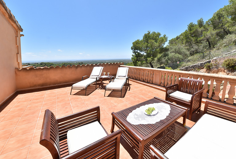 Terrasse mit Esstisch und Gartenmöbeln