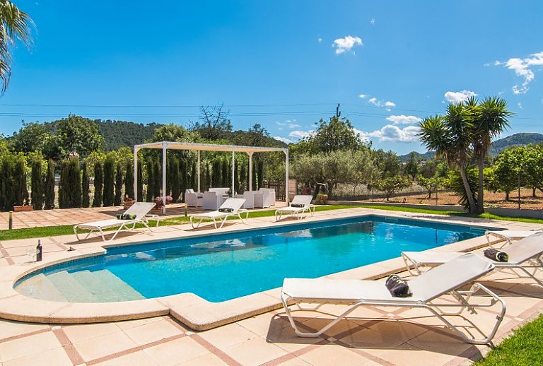 Poolbereich mit Sonnenliegen vor der Finca