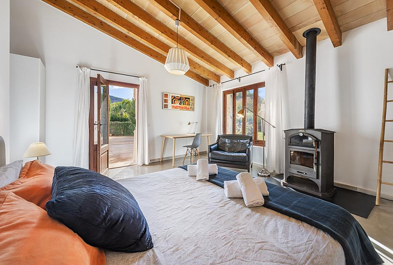 Schlafzimmer mit Doppelbett und Kamin