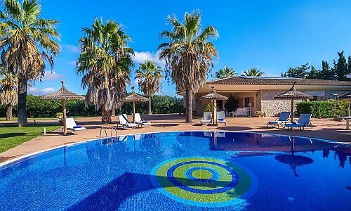 Pool mit Sonnenliegen und Sonnenschirm vor der Finca