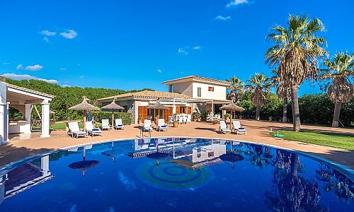 Poolbereich mit Liegen und Sonnenschirmen vor der Finca