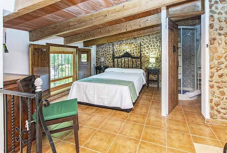 Schlafzimmer mit Doppelbett und Badezimmer