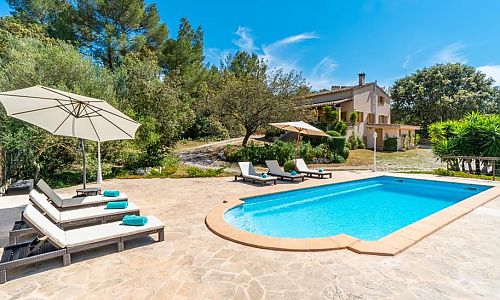 Poolbereich mit Sonnenliegen vor der Finca