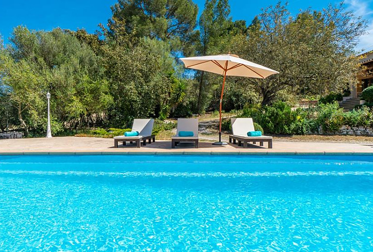 Sonnenschirm mit Liegen am Pool
