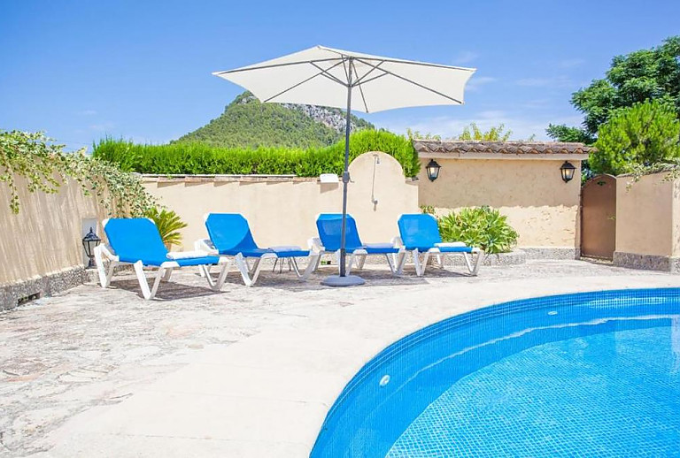 Sonnenschirm und Sonnenliegen am Pool
