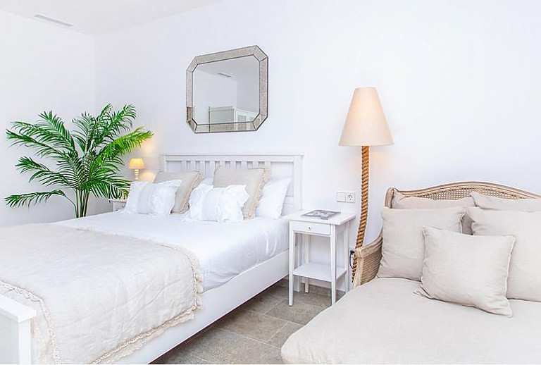 Schlafzimmer mit Doppelbett und Pflanze