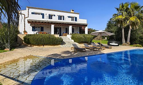 Außenbereich mit Pool und Sonnenliegen