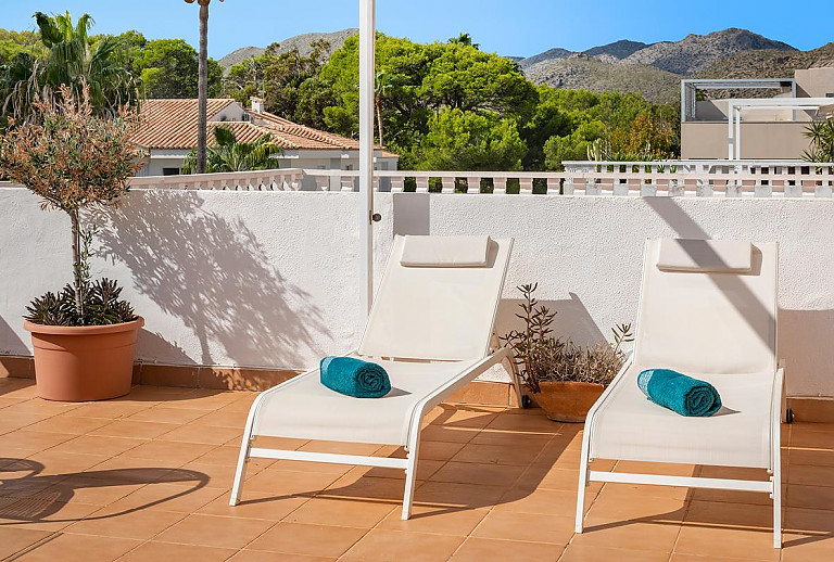 Sonnenliegen und Topfpflanzen auf der Terrasse