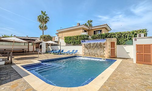 Poolbereich mit Sonnenliegen und Sonnenschirm