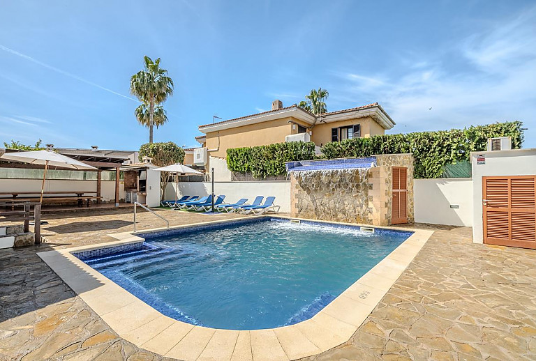 Poolbereich mit Sonnenliegen und Sonnenschirm