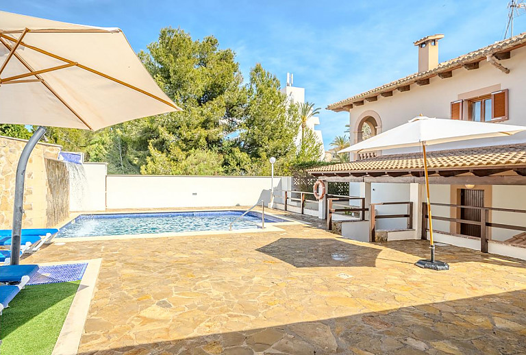 Poolterrasse mit Sonnenschirm und Poolliegen