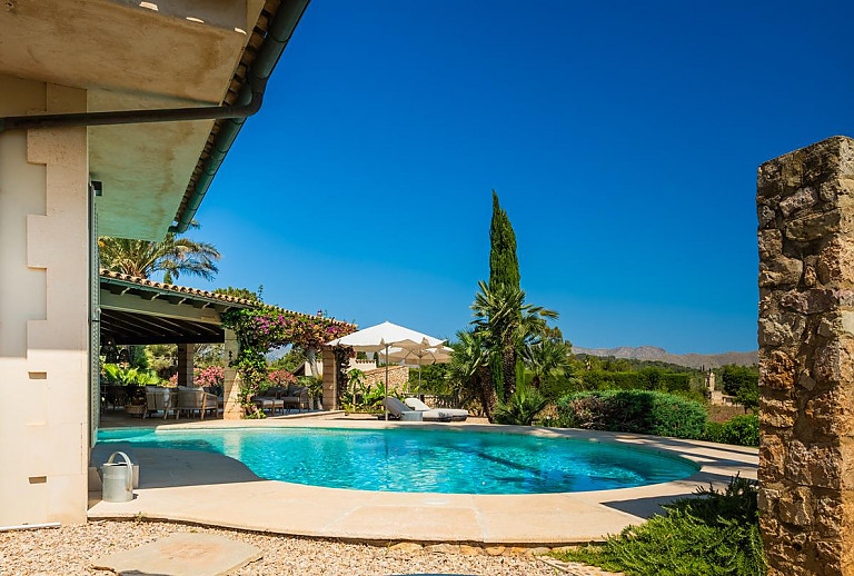 Außenbereich mit Pool und Sonnenschirm