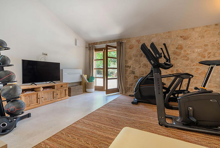 Fitnessraum mit Geräten und Fernseher