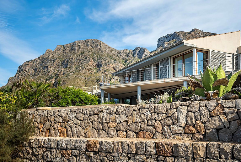 Poolterrasse mit Steinmauer vor dem Ferienhaus