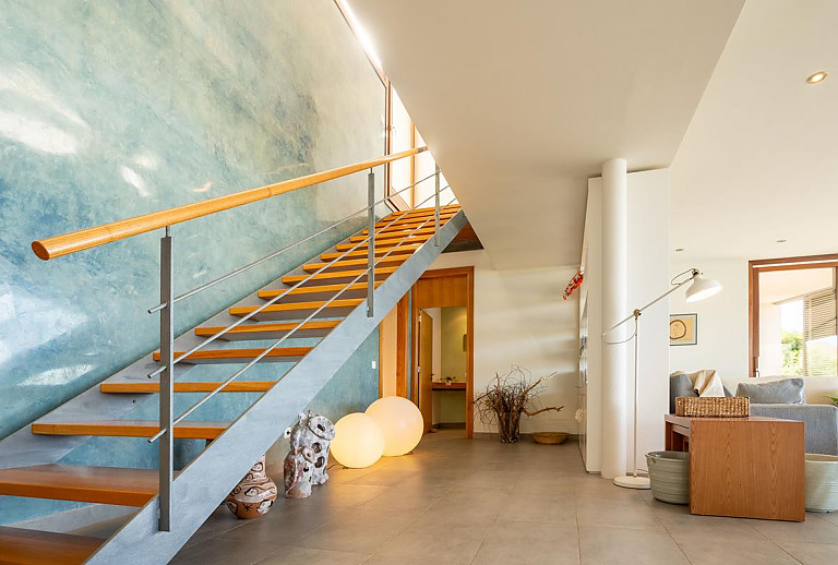 Wohnzimmer mit Treppenaufgang und Sofas
