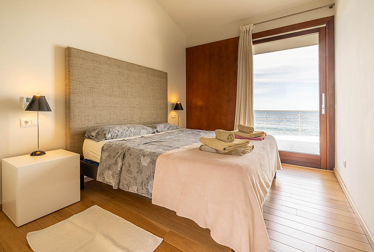 Schlafzimmer mit Doppelbett und Terrasse mit Meerblick