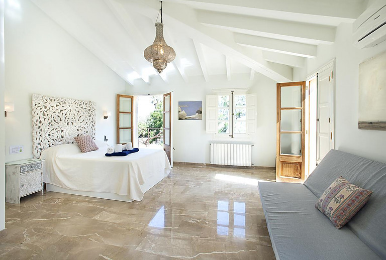 Schlafzimmer mit Doppelbett und Couch