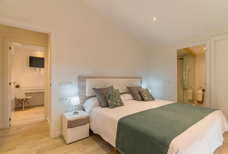 Schlafzimmer mit Doppelbett und Badezimmer