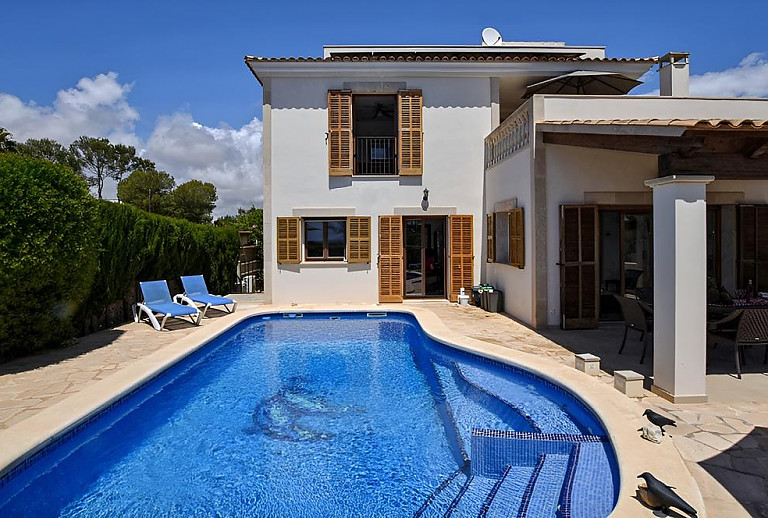Pool mit Sonnenliegen vor dem Ferienhaus