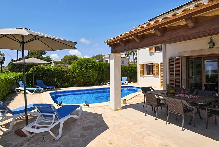 Terrasse mit Vordach und Esstisch am Pool