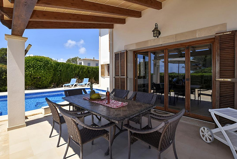 Terrasse am Pool mit Vordach und Esstisch