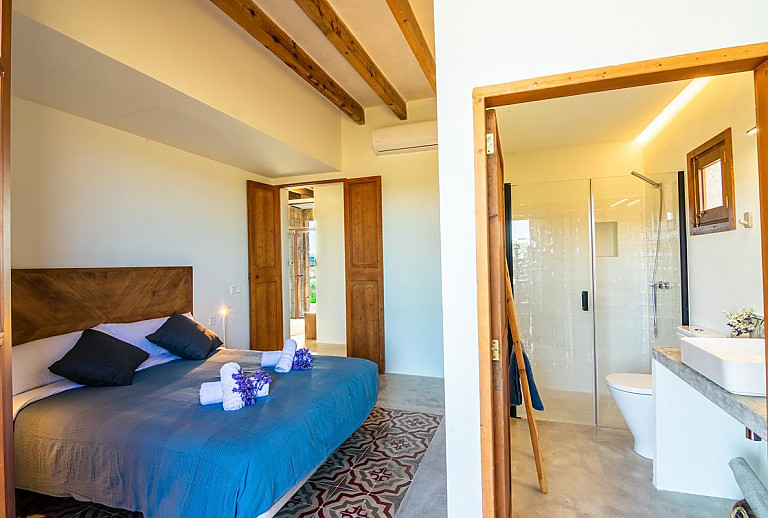 Schlafzimmer mit Doppelbett und Badezimmer