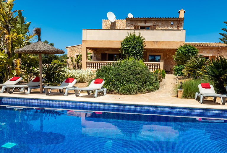 Pool mit Sonnenliegen und Sonnenschirm