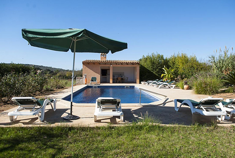 Poolliegen und Sonnenschirme am Poolbreich