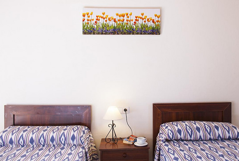 Schlafzimmer mit Einzelbetten und Wandbild