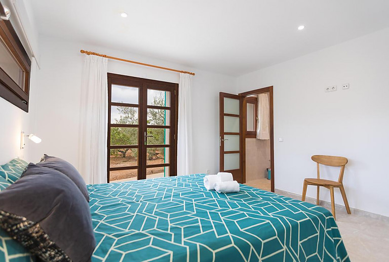 Schlafzimmer mit Doppelbett und Bad