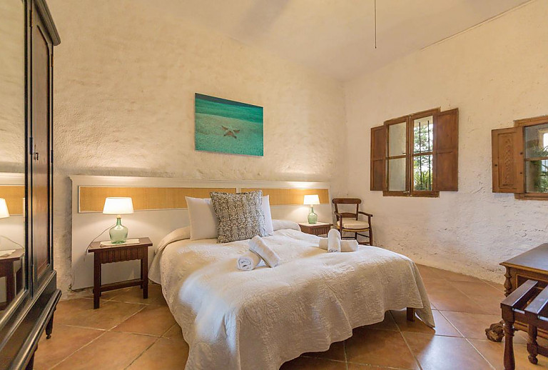 Schlafzimmer mit Doppelbett und Stuhl