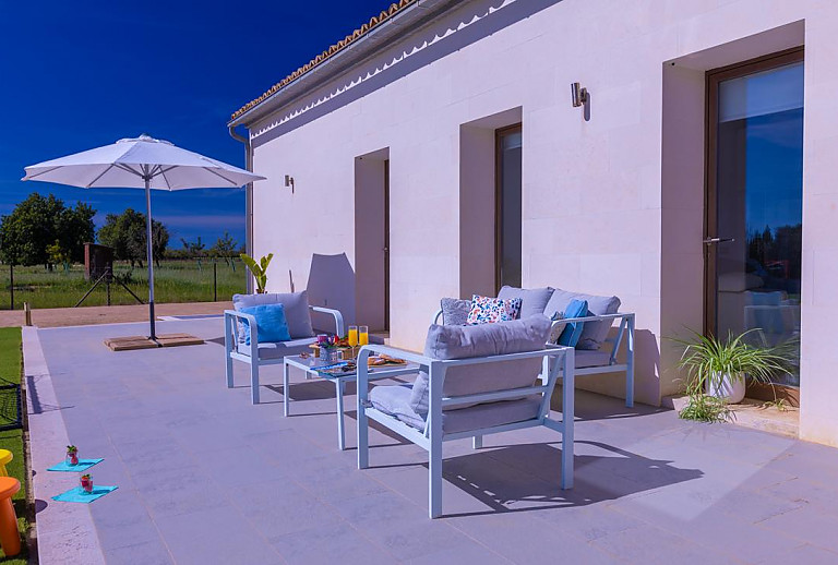 Terrasse mit Sonnenschirm und Gartenmöbeln