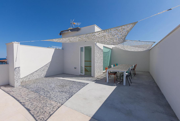 Esstisch auf der Terrasse mit Sonnensegel