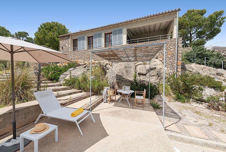 Sonnenliegen und Gartenmöbel vor der Finca