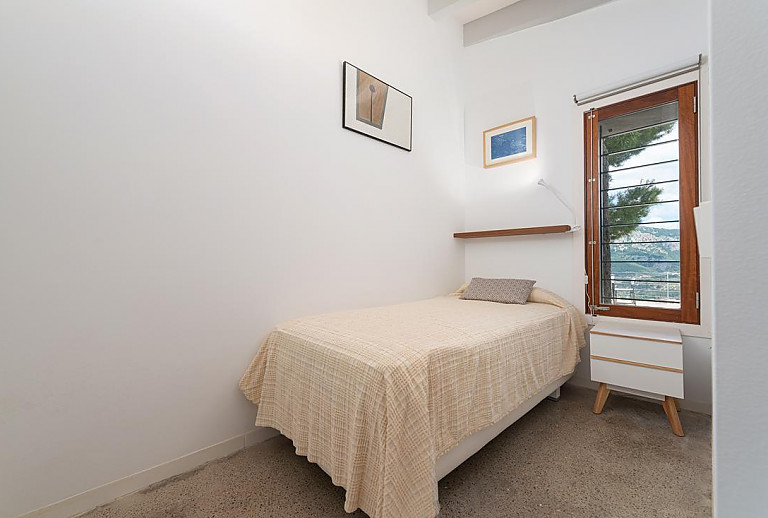 Schlafzimmer mit Einzelbett und Wandbildern