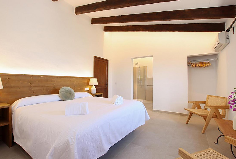 Schlafzimmer mit Doppelbett und Bad