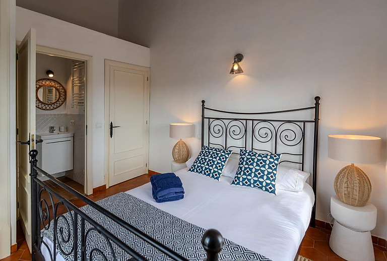 Schlafzimmer mit Doppelbett und Bad