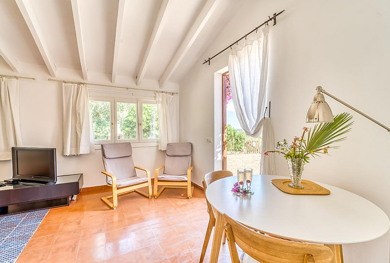 Wohnzimmer mit Fernseher und Esstisch