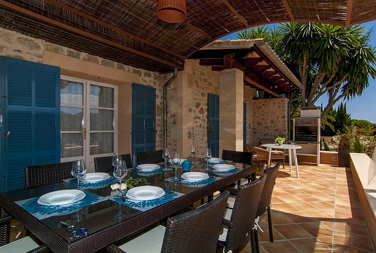 Grill auf der Terrasse mit Vordach und Esstisch