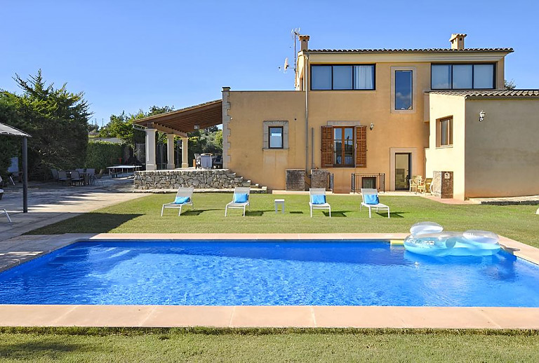 Poolbereich mit Rasenfläche und Sonnenliegen