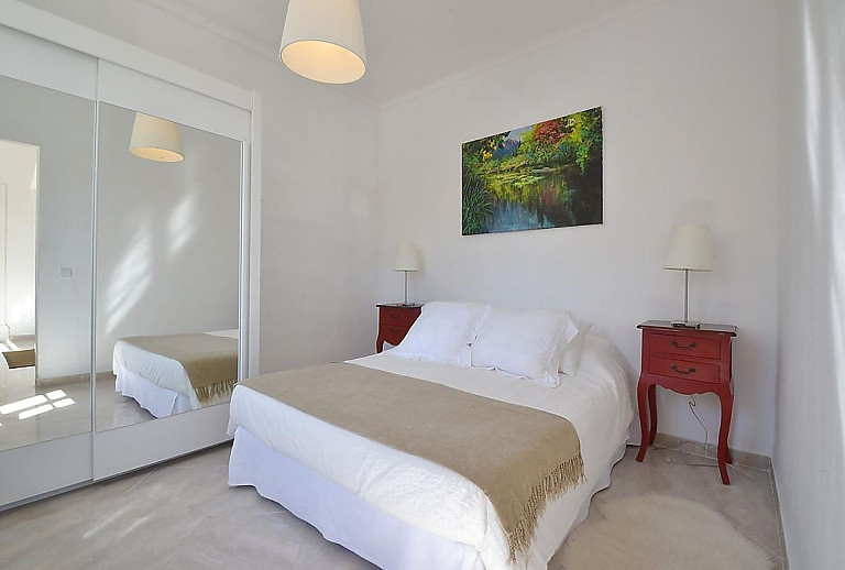 Schlafzimmer mit Doppelbett und Spiegelschrank