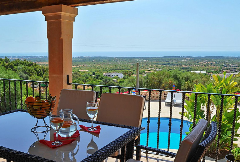 Terrasse mit Esstisch und Poolblick