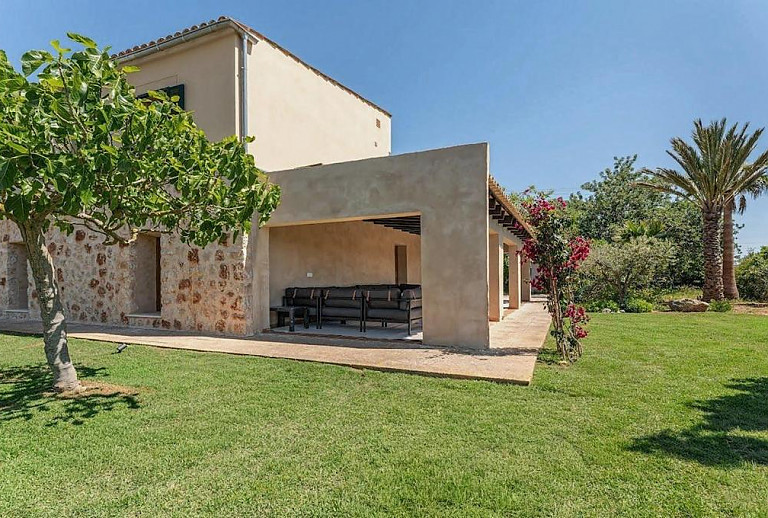 Garten mit Rasen und Palmen vor der Finca