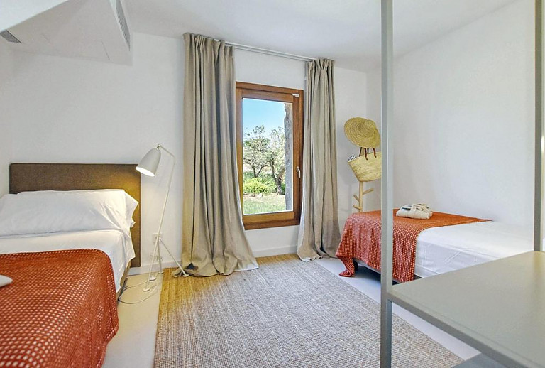Schlafzimmer mit Einzelbetten und Regal