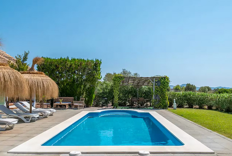 Sonnenschirme und Poolliegen am Pool
